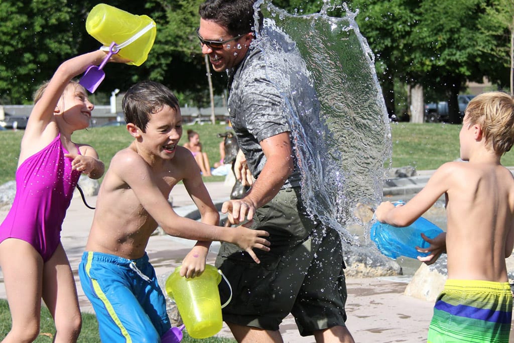Dad engaged in water play with kids to strengthen their relationship